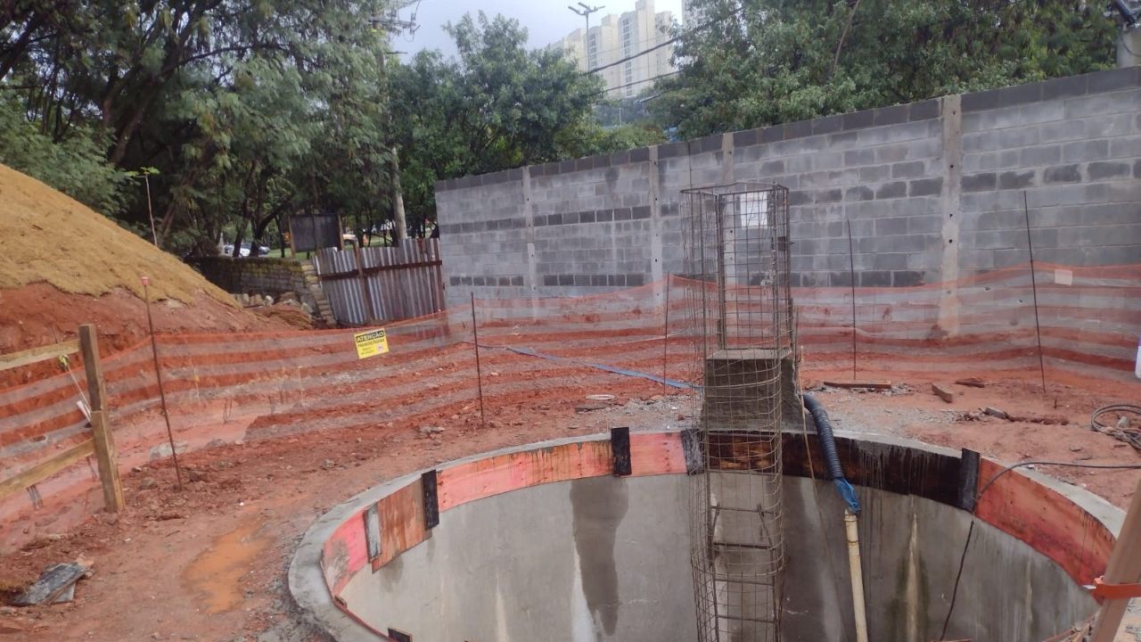 Poço circular de concreto armado executado em obra de drenagem, com armação central aparente.