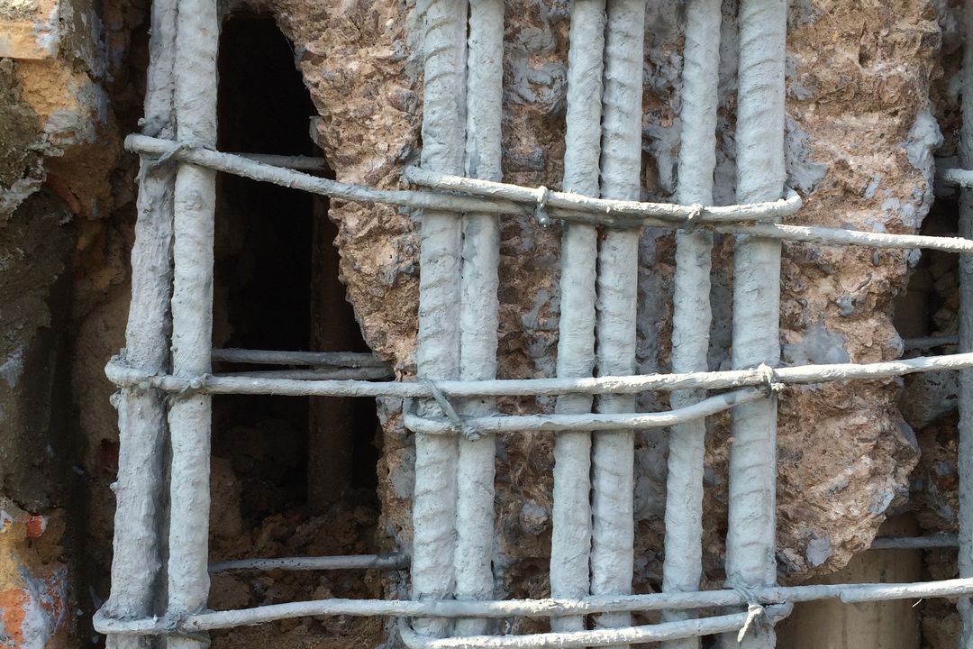 Armadura de uma viga exposta e tratada durante serviço de recuperação estrutural.